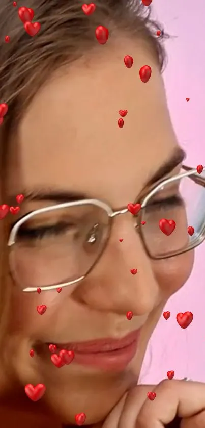 Smiling person with glasses surrounded by red hearts on a pink background.