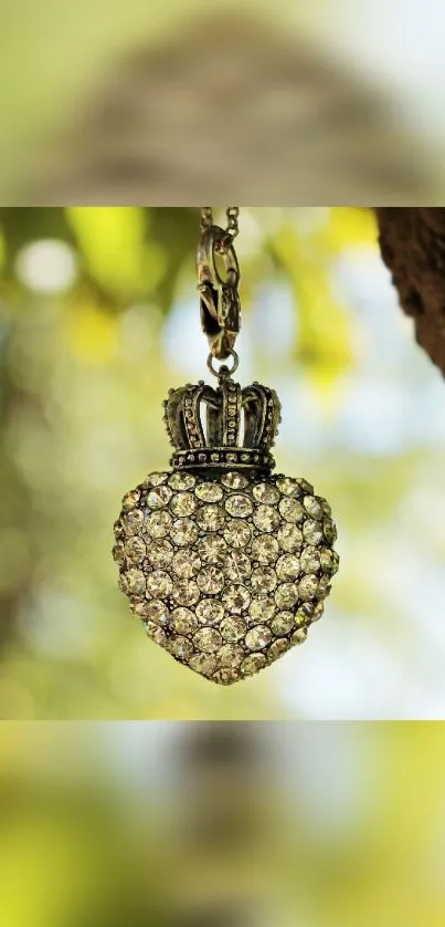 Heart-shaped pendant with sparkling stones hanging in front of a blurred nature background.