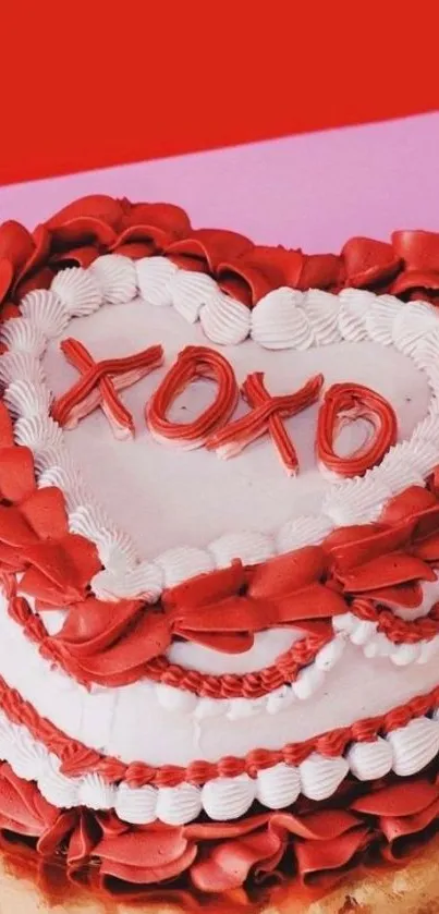 Heart-shaped cake with red frosting and 'XOXO' decoration.