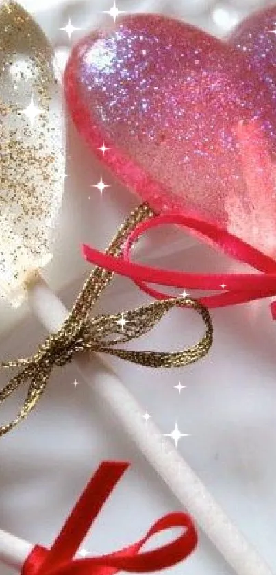 Heart-shaped glittery candy lollipops with bows on a plate.