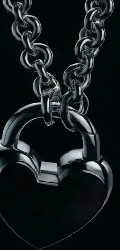 Heart-shaped metal lock with chain on black background.