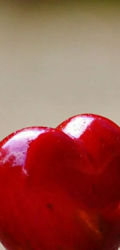 Heart-shaped cherry against soft background in rich red hues.