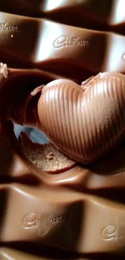 Heart-shaped chocolate on brown chocolate bar.