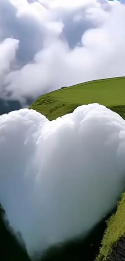 Heart-shaped cloud over lush green hill landscape.