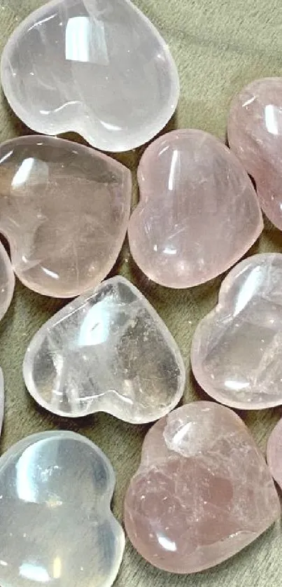 Heart-shaped rose quartz crystals on wood surface.