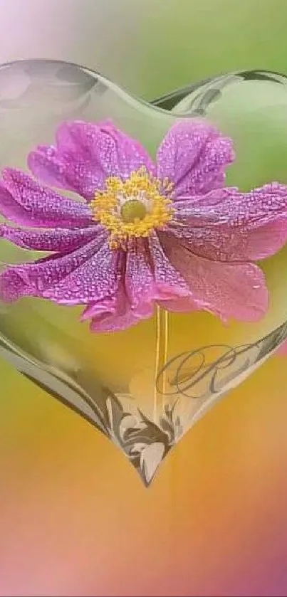 Heart-shaped crystal with pink flower inside, set on a colorful background.