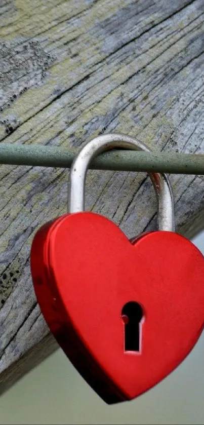 Red heart-shaped lock on rustic wood background.