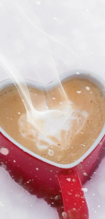 Heart-shaped red mug filled with coffee in the snow.