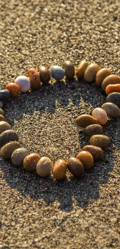 Heart-shaped pebble arrangement on sand beach wallpaper.