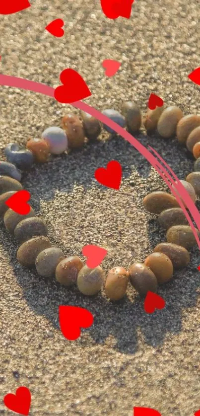 Heart-shaped pebble design with red hearts on sand background.