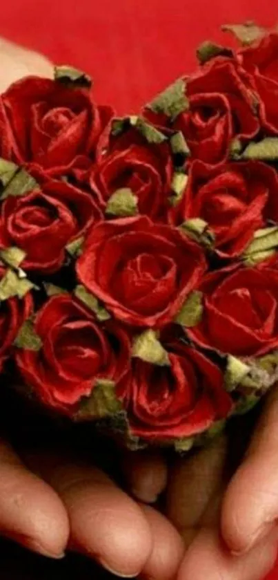 Heart-shaped red rose bouquet held in hands.