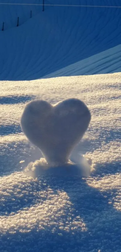 Heart-shaped snow sculpture at sunrise on a serene, snowy landscape.