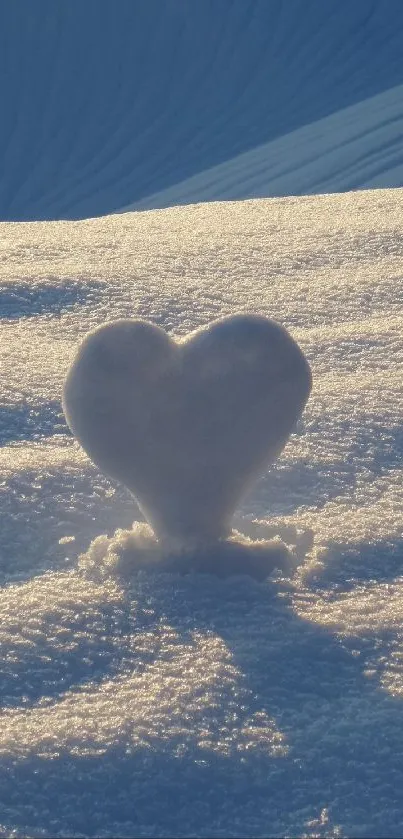 Heart-shaped snow formation on sunlit snowy hill