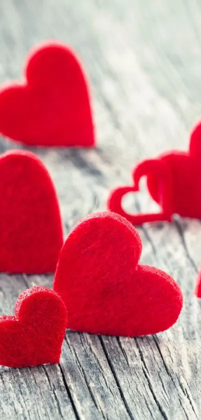 Red felt hearts on rustic wooden background, perfect for Valentine's Day.
