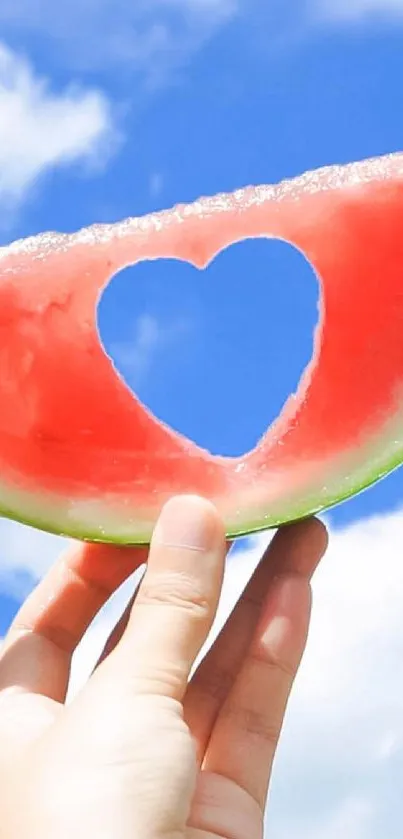 Heart-shaped watermelon slice against a sunny blue sky, creating a vibrant scene.