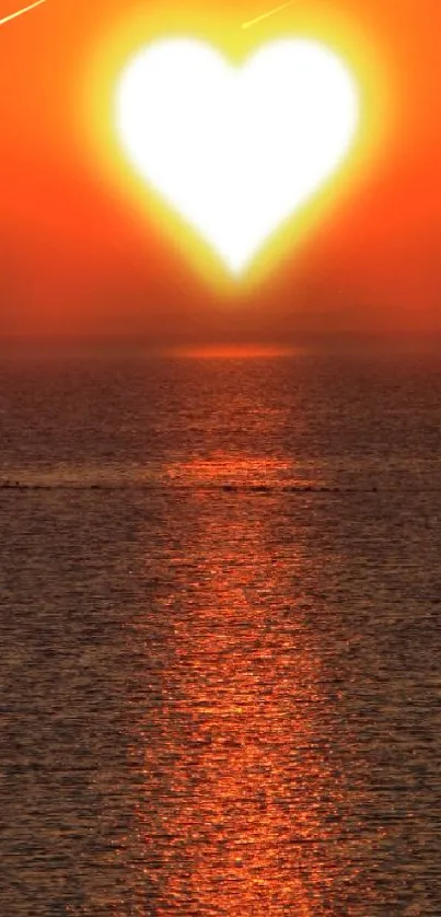 Heart-shaped sunset over ocean with reflection on water.