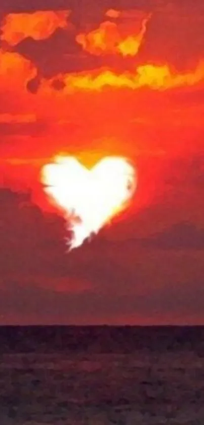 Heart-shaped cloud in sunset over ocean with vibrant orange hues.