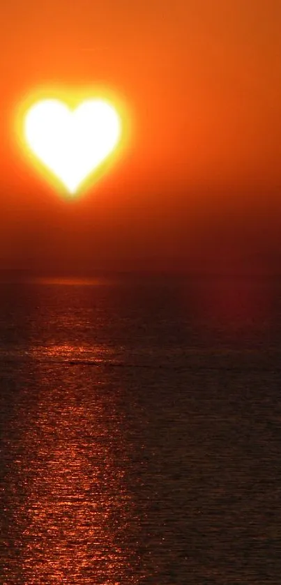 Heart-shaped sun setting over calm ocean waves.