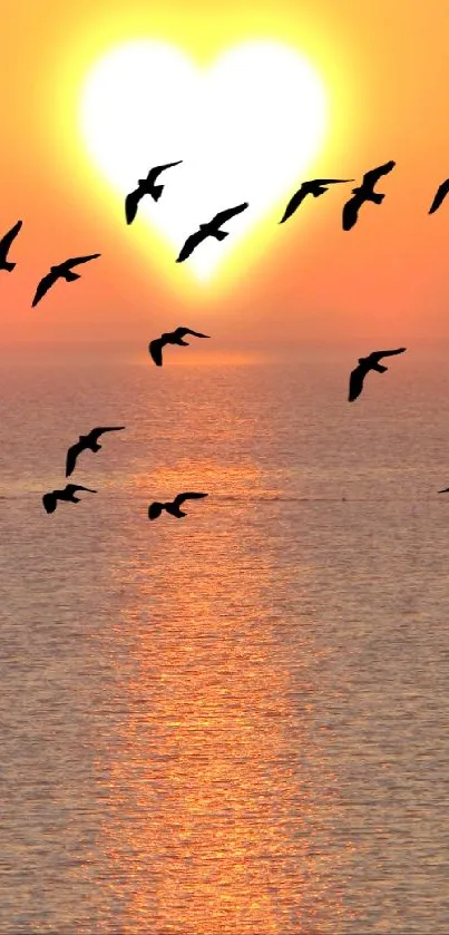 Heart-shaped sunset with birds over the ocean.