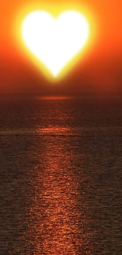 Heart-shaped sun setting over ocean at sunset