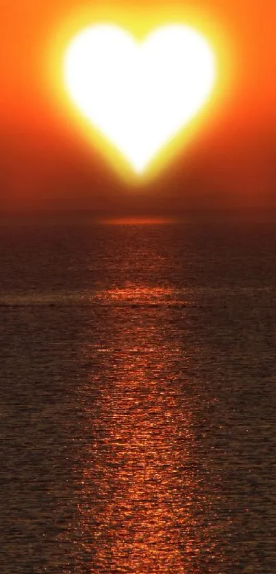 Sunset over ocean with heart-shaped sun reflecting light.