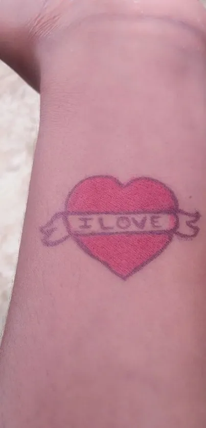 Heart tattoo with love banner on arm.