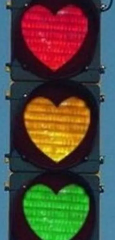 Heart-shaped traffic lights in red, yellow, and green against a blue sky.