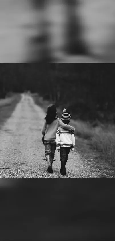 Black and white wallpaper of two kids walking on a path in nature.