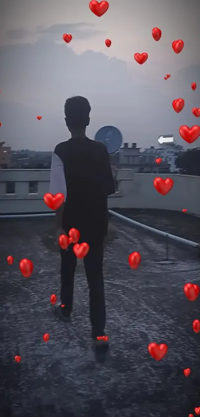 Silhouette on rooftop with red hearts floating in twilight sky.