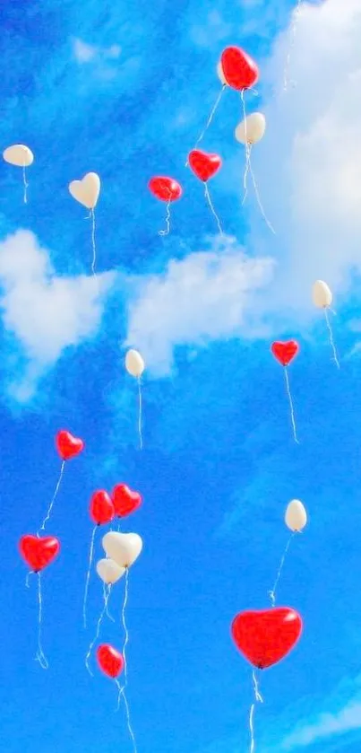 Heart balloons in a bright blue sky with clouds.