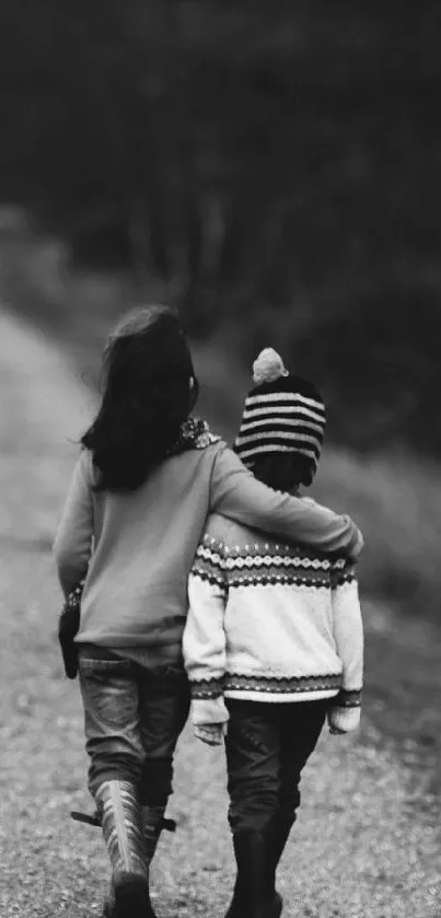 Black and white image of two children walking on a wooded path, embracing a moment.