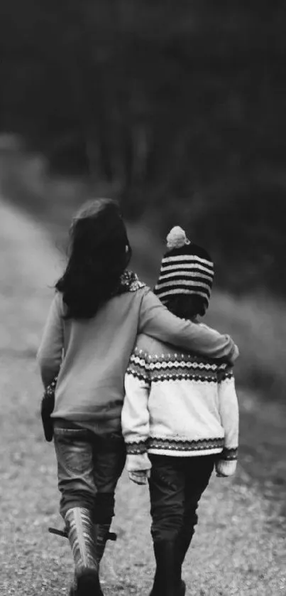 Black and white image of two children walking on a path.