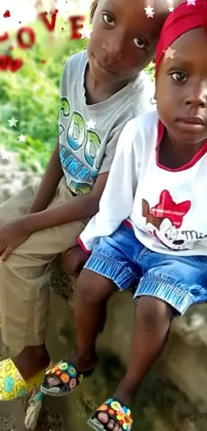 Two kids sitting outdoors with 'Love' in vibrant colors.