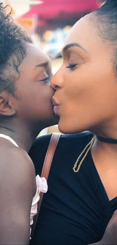 A mother and daughter sharing a loving kiss on mobile wallpaper.