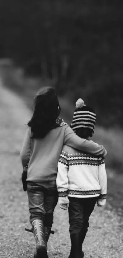 Black and white wallpaper of siblings walking arm in arm on a path.