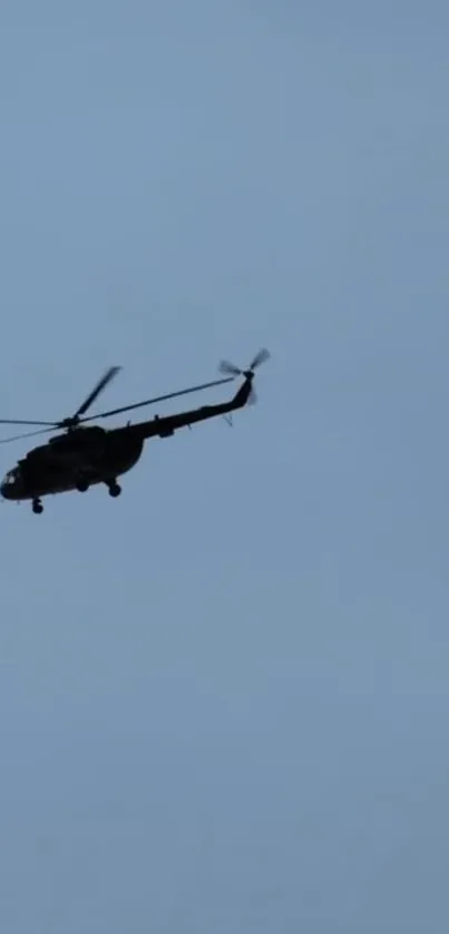 Silhouette of helicopter flying in clear blue sky wallpaper.