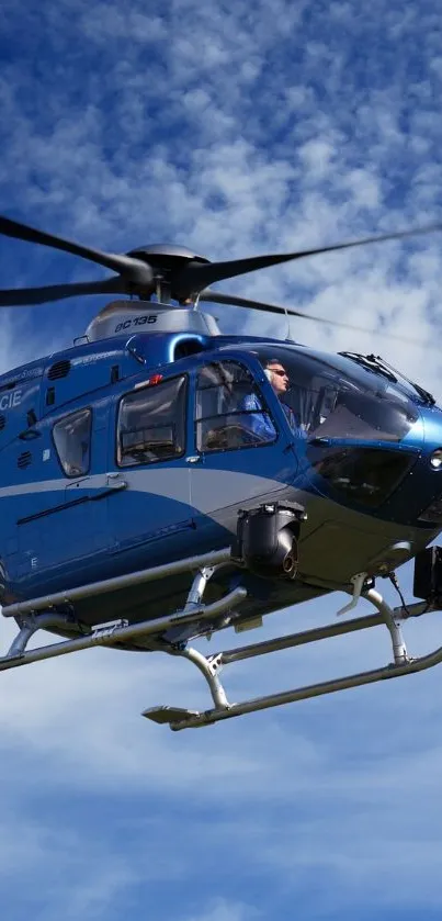 Helicopter soaring through clear blue sky with clouds.