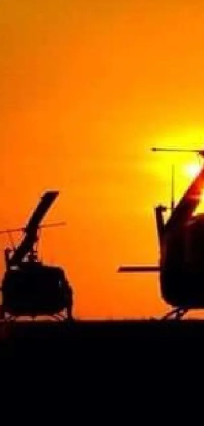 Silhouette of helicopters at sunset with vibrant orange sky.