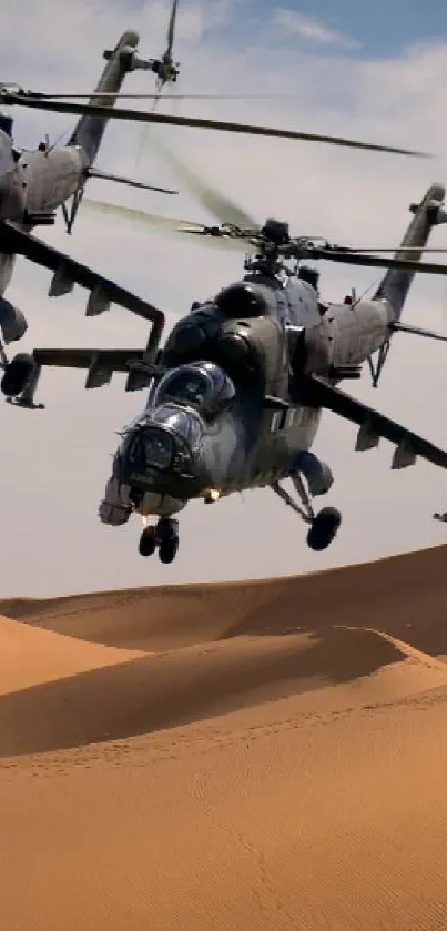 Military helicopters flying over desert sand dunes under blue sky.