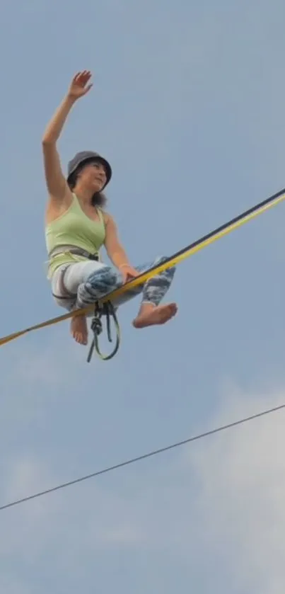 Person balancing on a slackline against a clear sky.