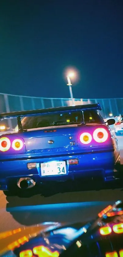 Blue sports cars driving fast at night on a neon-lit road.