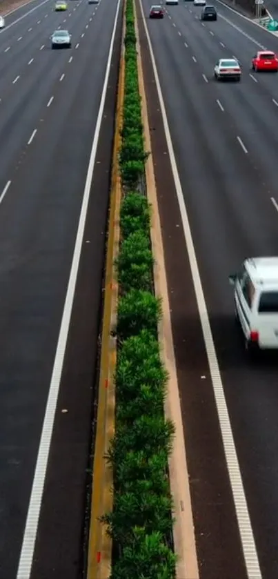 Aerial view of a bustling highway with vibrant greenery and moving cars.