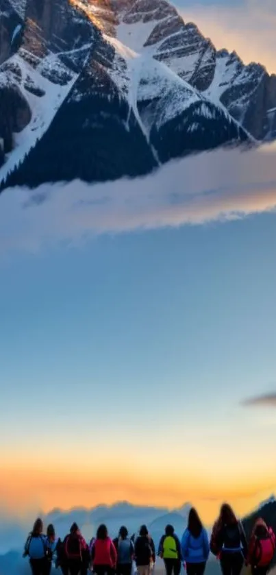 Group of hikers with snow-capped mountains under a vibrant sunset sky.