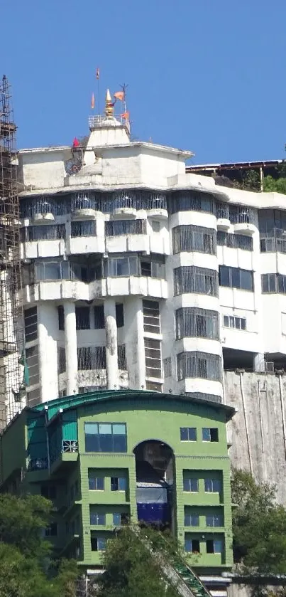 Hilltop building with unique architectural design and vibrant greenery.