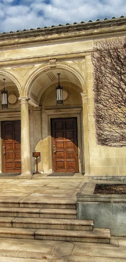 Historic building entrance with stone columns and wooden doors.