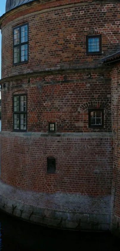 Brick castle wall by a calm water view.