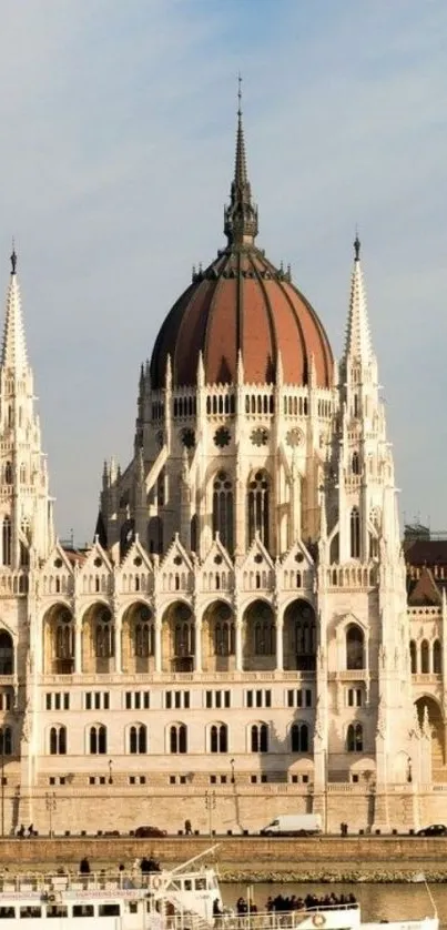 Historic building by river with architectural details and clear sky.