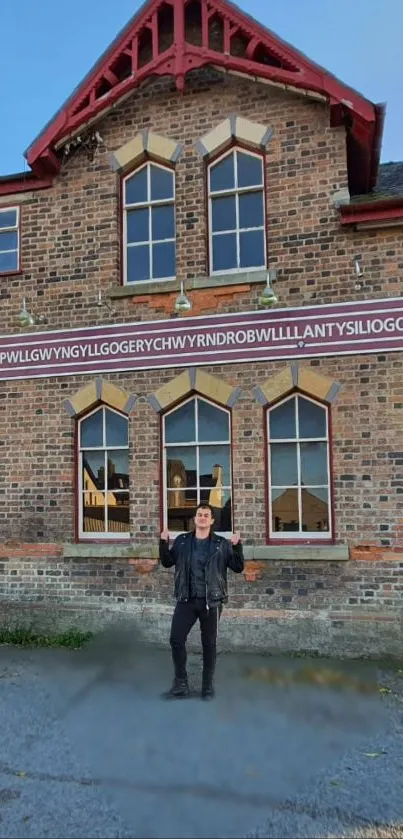 Historic building with a long sign and person posing.