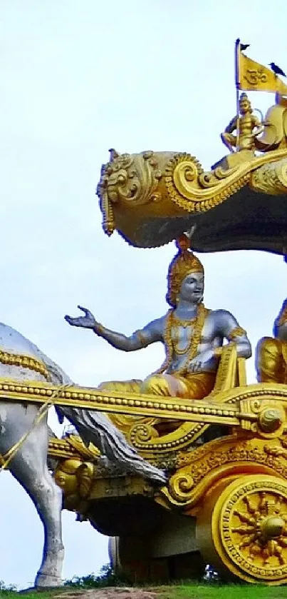 Golden chariot with horses on a green field under a blue sky.