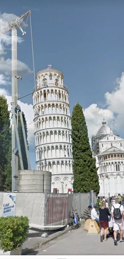 View of the Leaning Tower of Pisa with a clear blue sky and surrounding buildings.